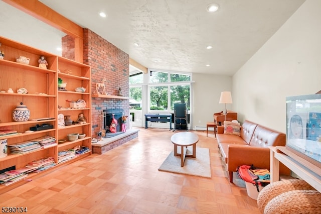 living room with brick wall, a brick fireplace, a baseboard heating unit, vaulted ceiling with beams, and light parquet flooring