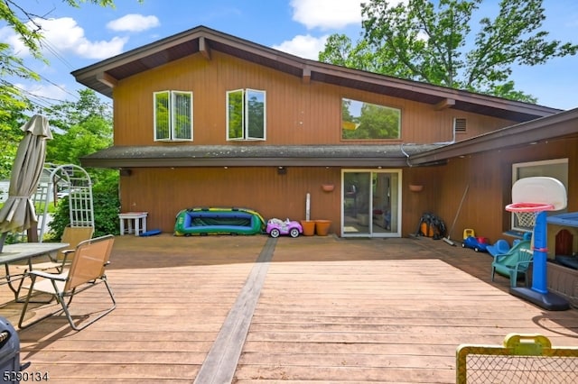 rear view of house featuring a wooden deck