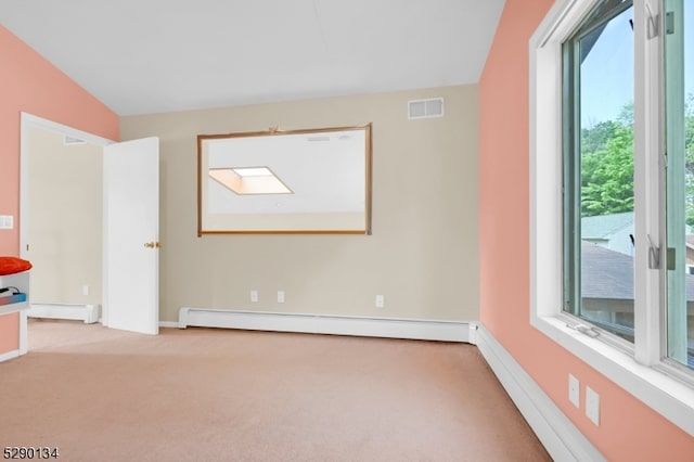 carpeted empty room with vaulted ceiling and a baseboard radiator