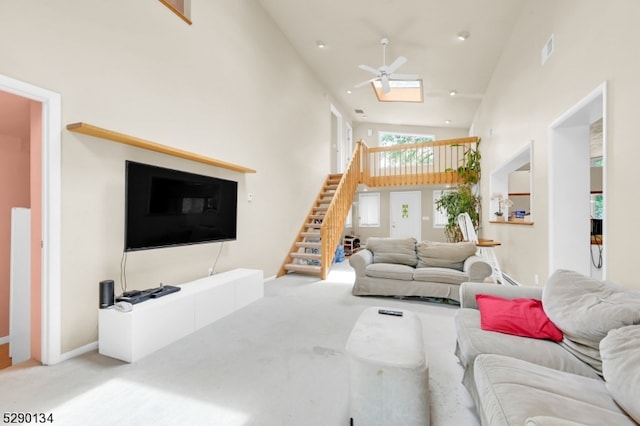 carpeted living room with high vaulted ceiling and ceiling fan