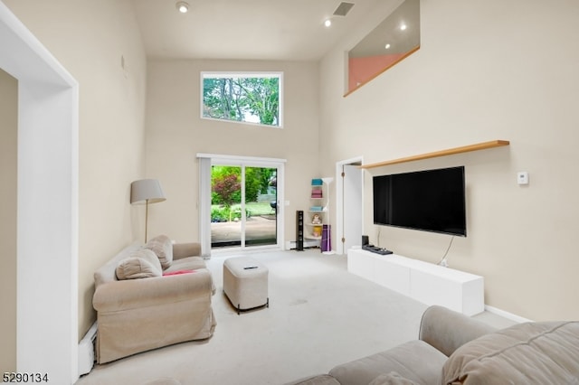 carpeted living room featuring high vaulted ceiling