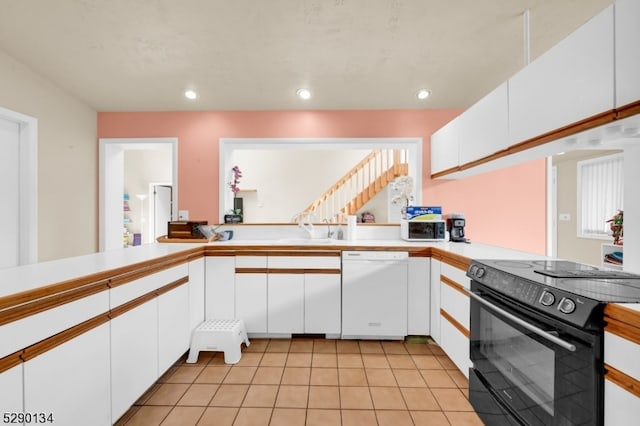 kitchen featuring black / electric stove, white cabinets, light tile flooring, and white dishwasher