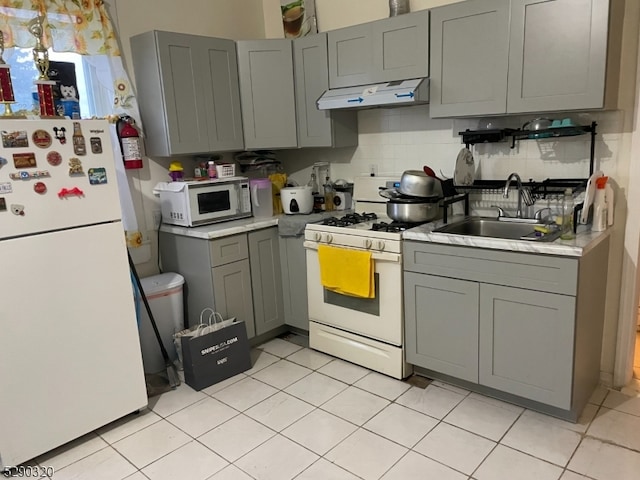 kitchen featuring light tile flooring, gray cabinetry, tasteful backsplash, sink, and white appliances