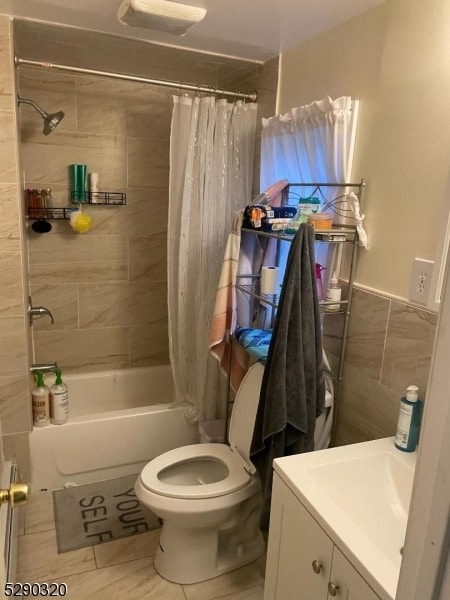 full bathroom with tile flooring, shower / tub combo with curtain, toilet, and vanity