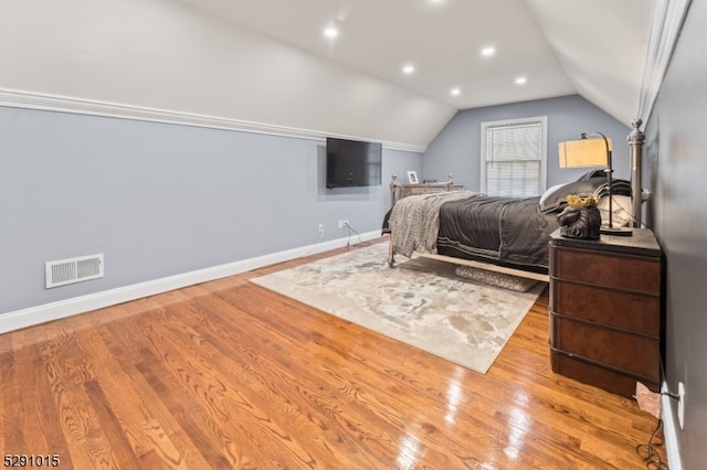 bedroom with vaulted ceiling and light hardwood / wood-style flooring