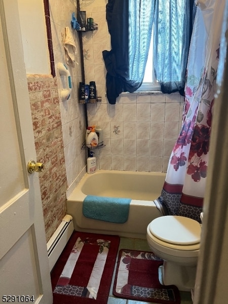 bathroom featuring a baseboard radiator, shower / tub combo, and toilet