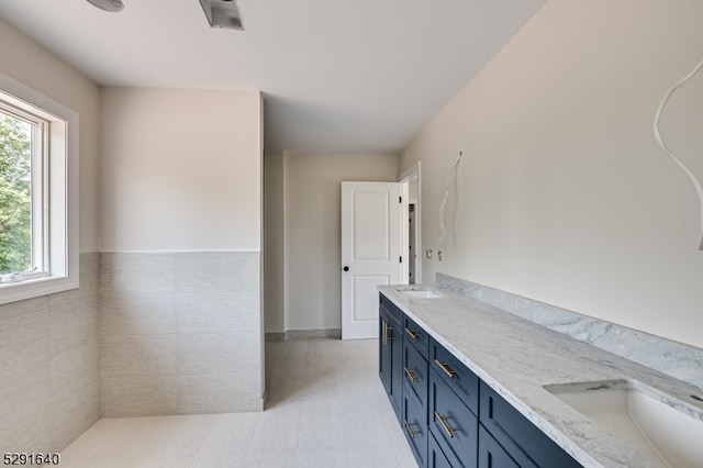 bathroom with vanity and tile walls