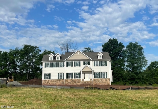 colonial-style house featuring a front lawn