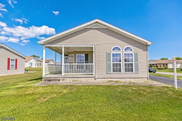 back of property with a porch and a lawn