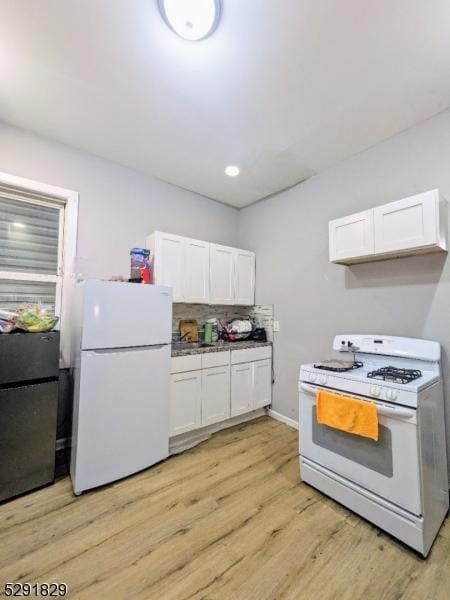 kitchen with backsplash, white cabinets, light hardwood / wood-style floors, and white appliances