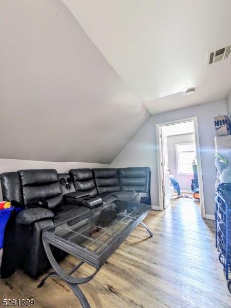 interior space featuring lofted ceiling and light wood-type flooring