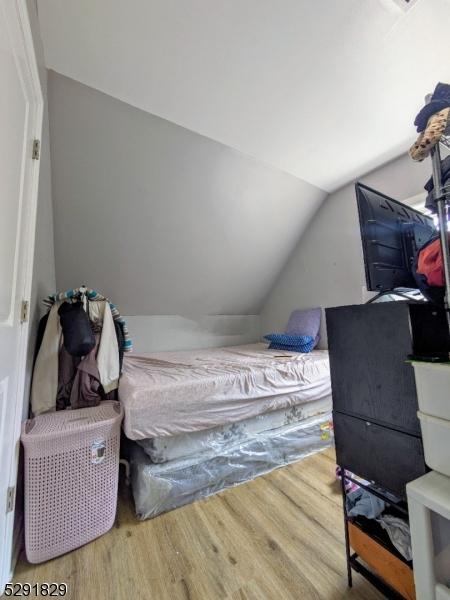 bedroom with hardwood / wood-style floors and vaulted ceiling