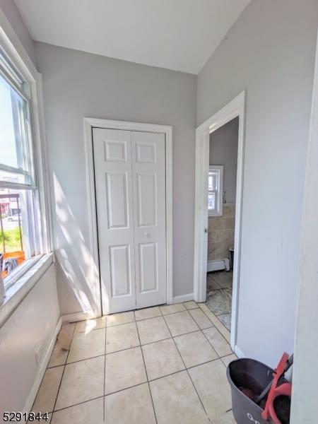 tiled bedroom featuring multiple windows and a closet