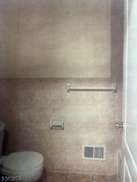 bathroom with toilet and tile patterned floors