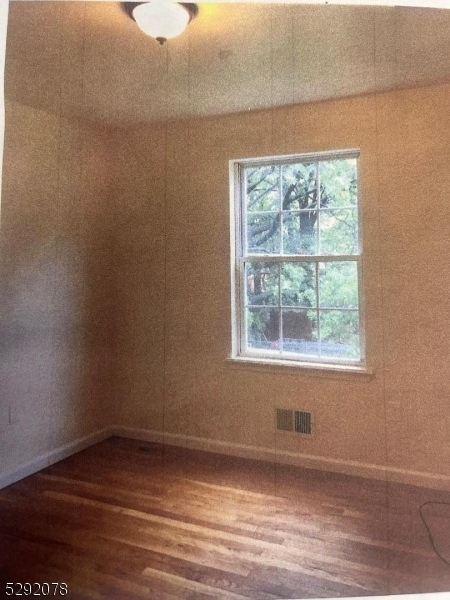 unfurnished room with hardwood / wood-style flooring