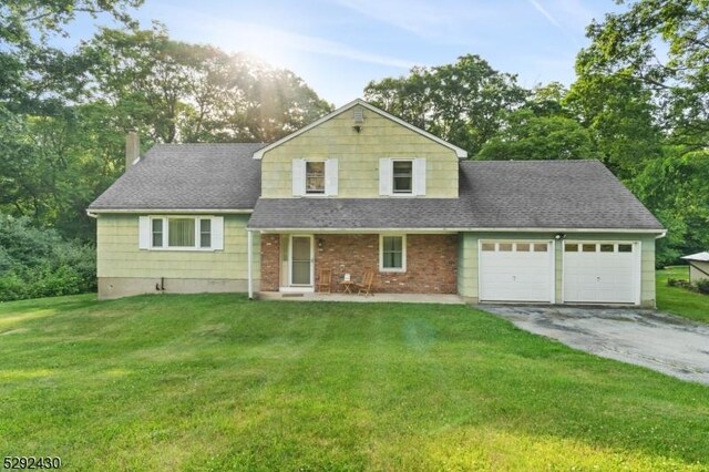 view of front of house featuring a front lawn and a garage