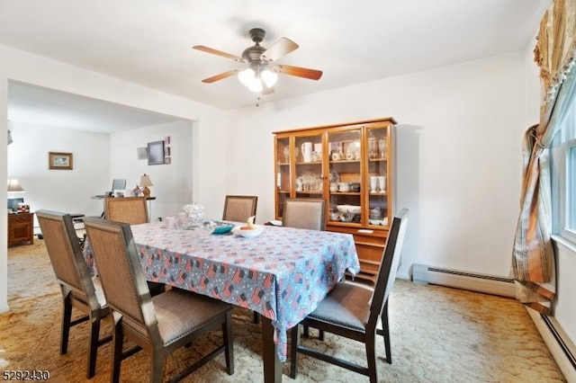 dining space featuring a baseboard radiator, light colored carpet, and ceiling fan