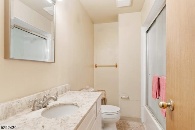 full bathroom with vanity, enclosed tub / shower combo, and toilet