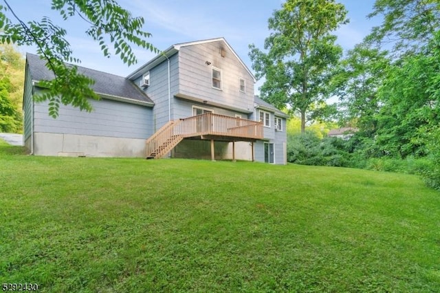 rear view of house featuring a yard and a deck