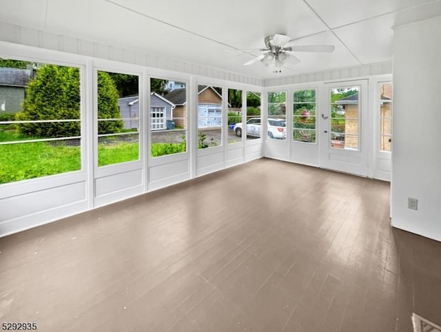 unfurnished sunroom featuring ceiling fan