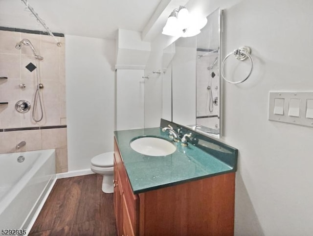 full bathroom featuring vanity, toilet, wood-type flooring, and tiled shower / bath