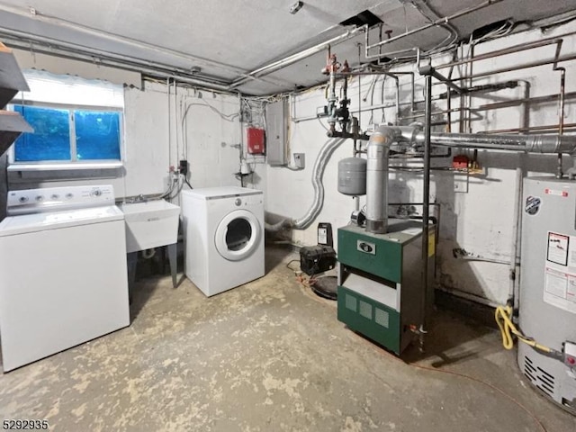 washroom featuring washer and clothes dryer, electric panel, water heater, and sink