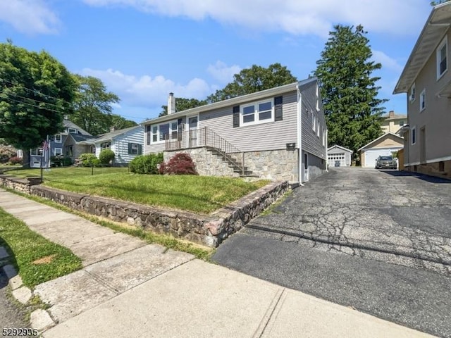 view of front of house with a front yard and an outdoor structure