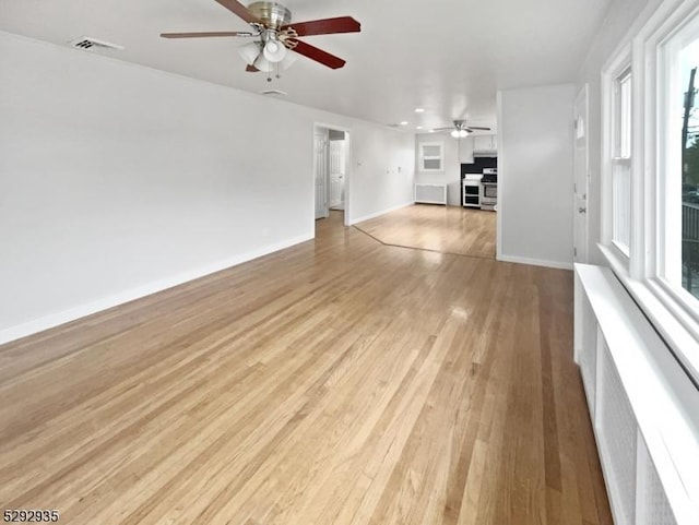 unfurnished living room with light hardwood / wood-style flooring and ceiling fan