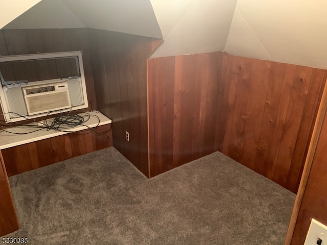 bonus room featuring vaulted ceiling, carpet, and wood walls