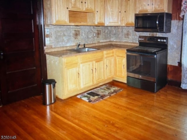 kitchen featuring electric stove, sink, backsplash, hardwood / wood-style floors, and light brown cabinetry