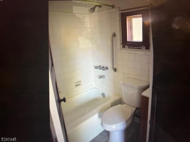 bathroom featuring toilet and tiled shower / bath