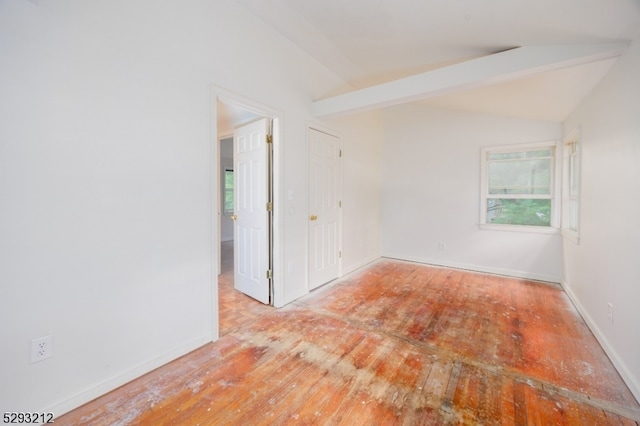 unfurnished room with lofted ceiling with beams and light hardwood / wood-style floors