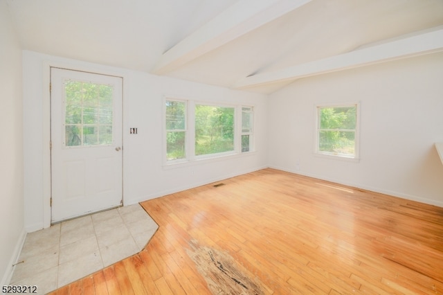 entryway featuring light hardwood / wood-style flooring and vaulted ceiling with beams