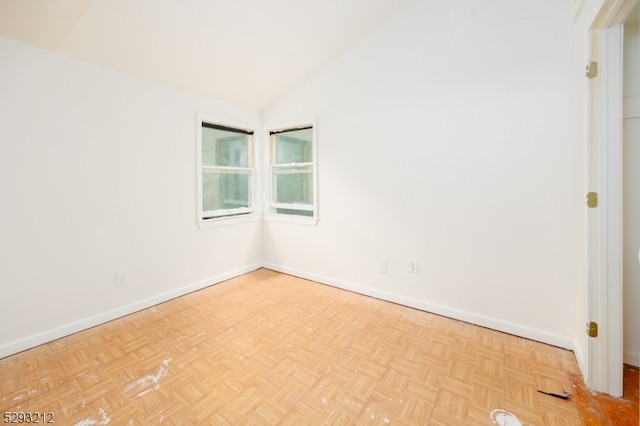 unfurnished room with lofted ceiling and light parquet flooring