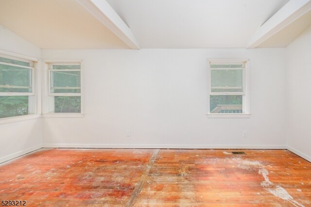 unfurnished room featuring lofted ceiling with beams