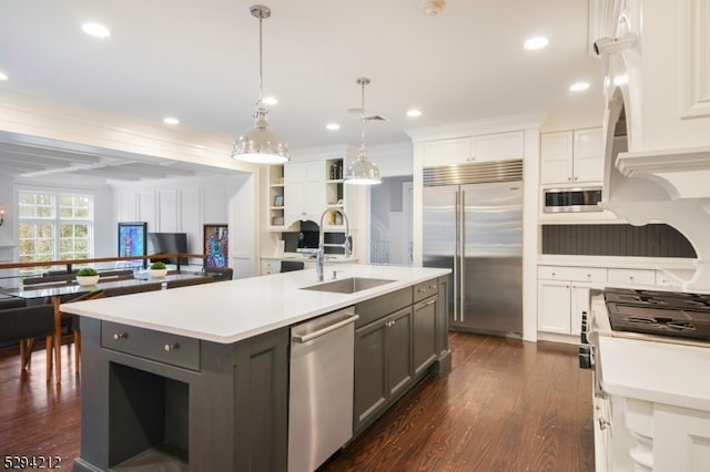 kitchen with gray cabinetry, a kitchen island with sink, white cabinets, sink, and built in appliances