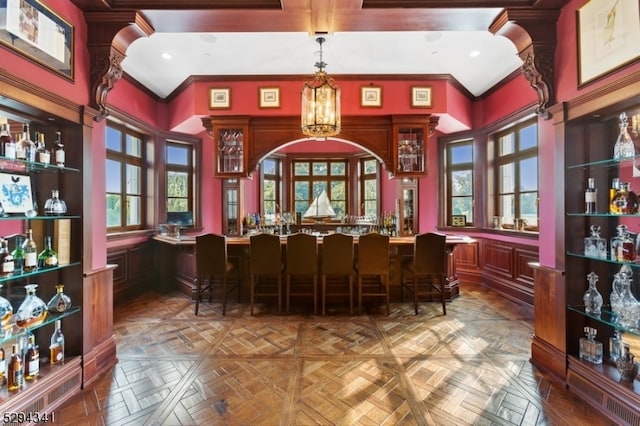 interior space with a high ceiling, ornamental molding, and parquet floors