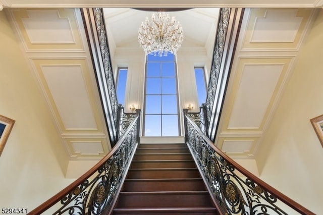 stairs featuring a chandelier and a towering ceiling