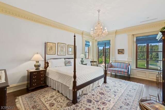 bedroom featuring dark hardwood / wood-style floors, crown molding, and a chandelier