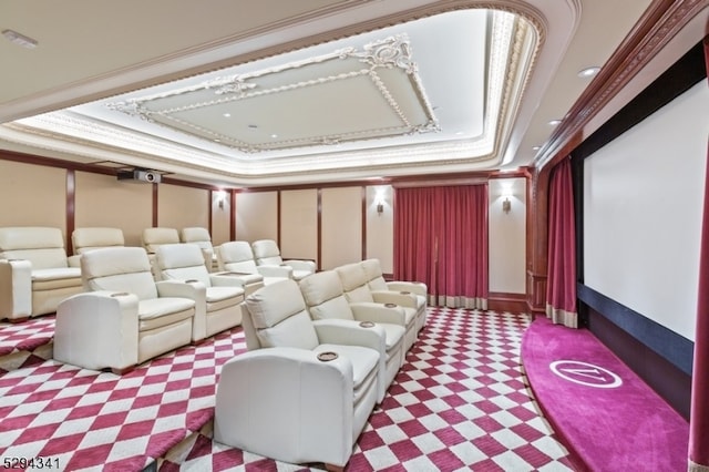 carpeted home theater room featuring a raised ceiling and ornamental molding