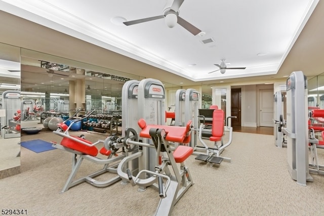 exercise room featuring carpet, ceiling fan, a tray ceiling, and crown molding