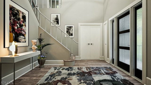 entryway with a towering ceiling and hardwood / wood-style flooring