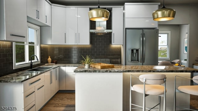 kitchen with decorative light fixtures, sink, tasteful backsplash, and stainless steel refrigerator with ice dispenser