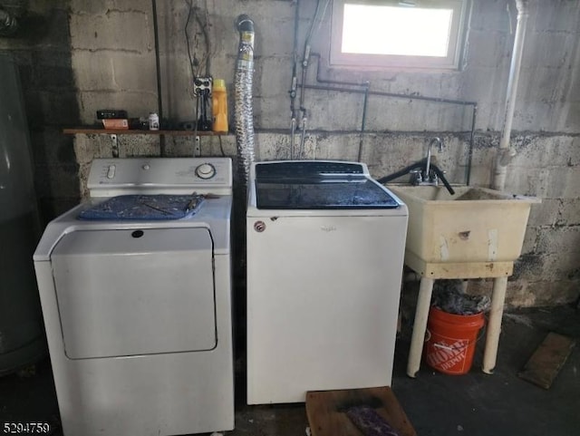 clothes washing area with separate washer and dryer and sink