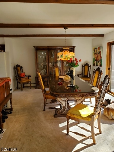 carpeted dining room with beam ceiling