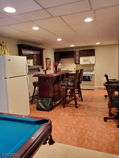 rec room featuring bar, a paneled ceiling, billiards, and light tile floors