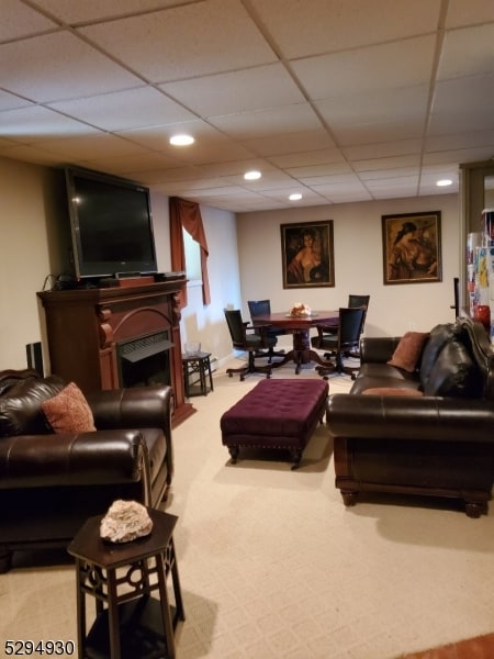 carpeted living room featuring a paneled ceiling