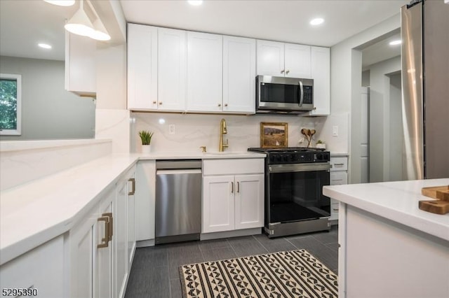 kitchen featuring white cabinets, appliances with stainless steel finishes, backsplash, and sink