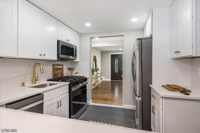 kitchen featuring stainless steel appliances, white cabinets, tasteful backsplash, and sink