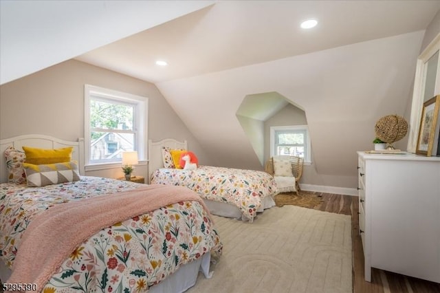 bedroom featuring multiple windows, vaulted ceiling, and light wood-type flooring